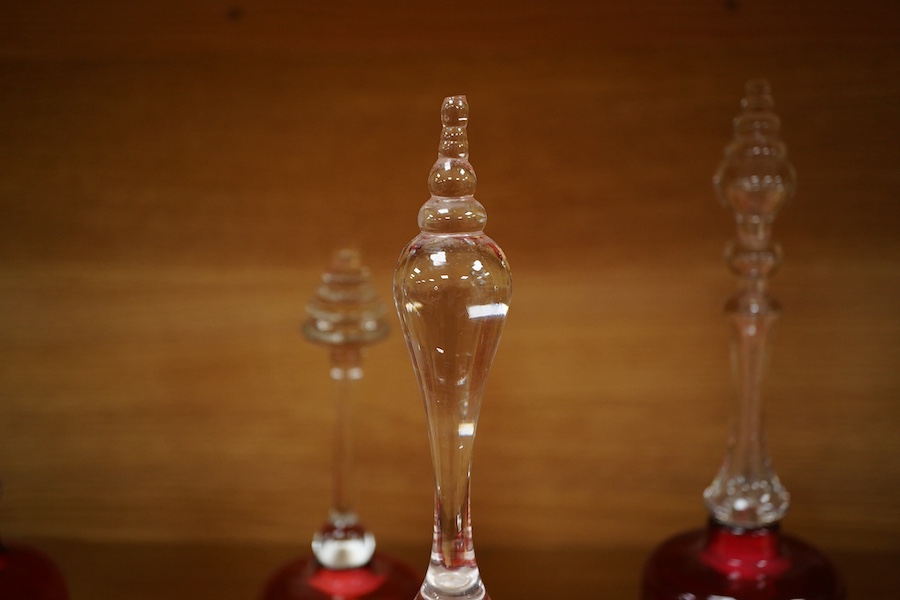 Seven Victorian cranberry glass bells, one with patriotic opaque twist handle, largest 30cm high. Condition - fair/good
